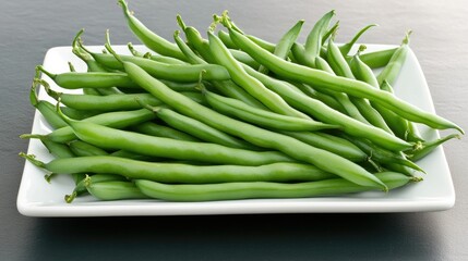 Obraz premium Fresh green beans harvested from a garden, arranged on a white plate against a dark background for a vibrant and refreshing look