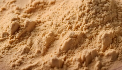 Ground ginger texture forming soft, light golden dunes under warm lighting