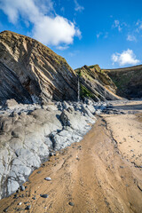 Rocks and waterfall coming from the cliffs at Sandymouth Bay