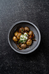 Delight in a beautifully presented bowl of tender roasted potatoes topped with a velvety poached egg and garnished with fresh herbs