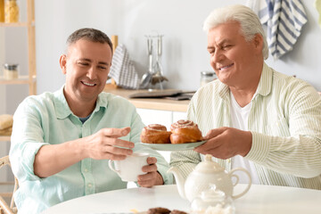Mature brothers having breakfast in kitchen