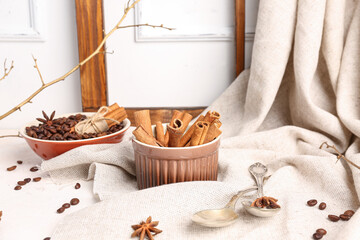 Composition with cinnamon sticks and coffee beans on light background