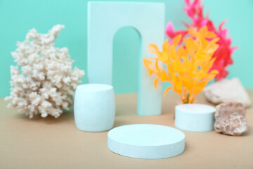 Decorative plaster podiums, seaweed and coral on turquoise background