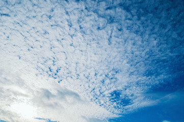 Cloudy blue sky background, picturesque cloudy sky lit by sunshine in the evening