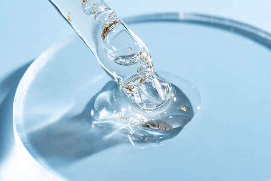 Close-up of a cosmetic pipette with liquid and gold flakes - Powered by Adobe