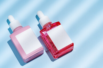 Top view of cosmetic bottles with tulips on blue background