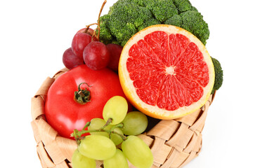 Wicker basket with different fresh fruits and vegetables on white background