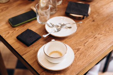 Empty coffee cup on a wooden table after drinking. Cafe culture.