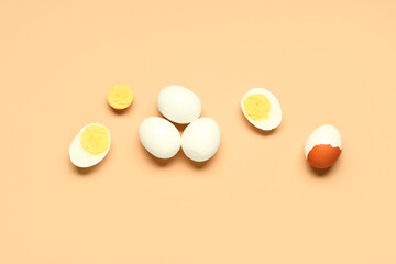 Tasty boiled eggs with halves on orange background