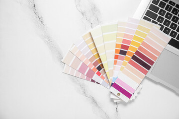 Many color palettes and laptop on light background