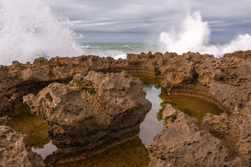 A rocky shoreline with a large body of water in the background