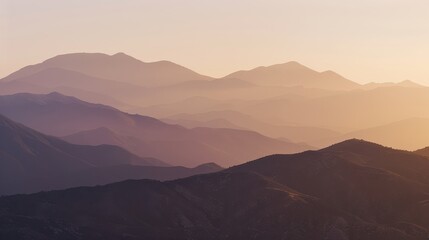 Naklejka premium Serene Mountain Sunrise with Warm Sunlight and Cool Shadows