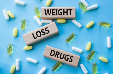 Medicine symbol. Concept words Weight Loss Drugs on wooden blocks. Beautiful blue background with...