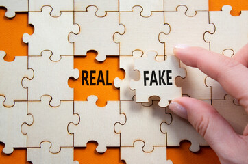 Real or Fake symbol. Concept word Real or Fake on wooden blocks. Businessman hand. Beautiful orange...