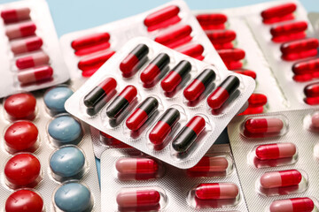 Blister packs with different pills on blue background