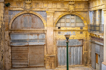 Fototapeta premium Typical narrow streets with colorful balconies in VallettaTypical narrow streets with colorful balconies. Narrow streets with colourful window boxes in Valetta, Malta Traditional Maltese balconies