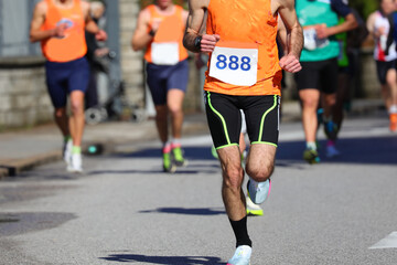 Runner with bib number 888 running during the marathon in the city