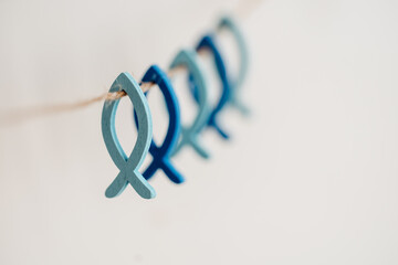 Kleine blaue Fische aus Holz an natur Schnur - Symbol für Glaube und Religion