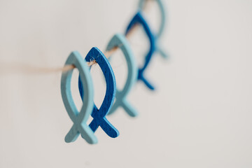 Kleine blaue Fische aus Holz an natur Schnur - Symbol für Glaube und Religion