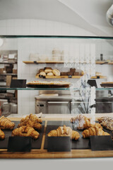 Interior details at the bakery and coffee shop. Bistro showcase with shelves of freshly croissants and bread in assortment.
