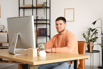 Young bearded man using computer at table in office