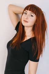 Stylish woman poses with confidence. A woman with long red hair strikes a playful pose against a...