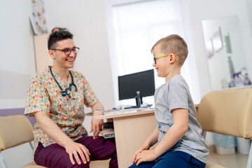 Doc with young patient. A healthcare professional engages with a child during a check-up at a modern medical facility.