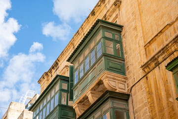 Obraz premium Typical narrow streets with colorful balconies in VallettaTypical narrow streets with colorful balconies. Narrow streets with colourful window boxes in Valetta, Malta Traditional Maltese balconies