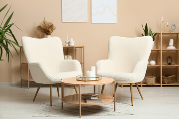 Interior of modern living room with armchairs, coffee table and burning candles