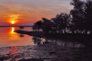 Daylight comes to an end as the sun slowly sinks to the horizon while providing a colorful sunset...