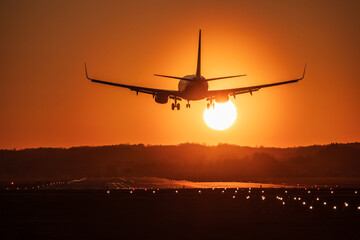 Airplane landing with a golden light of sunset in Cracow Balice Airport during a februray day.