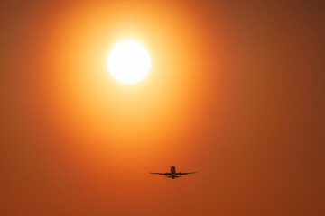 Airplane landing with a golden light of sunset in Cracow Balice Airport during a februray day.
