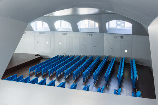 Modern auditorium with blue seats and natural light