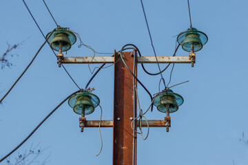 Rusty Electrical Pole with Glass Insulators. Rusty electrical pole with glass insulators against a...