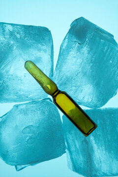 Glass ampoule resting on blue ice cubes for cooling effect