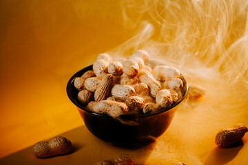 Hot peanuts steaming in a black bowl against a warm golden backdrop during a cozy gathering