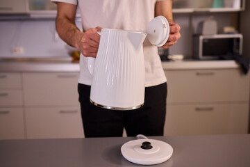 Unboxing a stylish, modern kettle designed for use in a bright, contemporary kitchen space