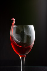A delightful glass of rich red wine accompanied by a splash on the side