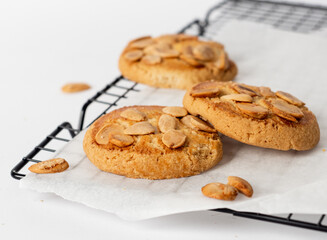 Bunch of almond cookies on a cooling tray with a white background