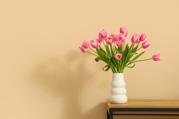 Vase with bouquet of beautiful tulip flowers on bench near beige wall, closeup