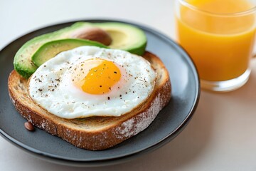 Healthy Breakfast: Avocado Toast with Fried Egg and Fresh Orange Juice on Plate