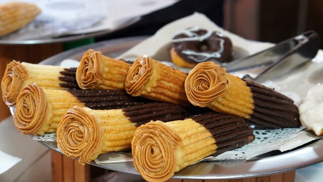 typical spanish sweet, porras covered with chocolate and filled with sweet cream and sugar sprinkled