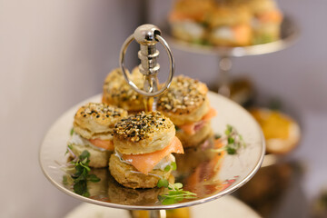 Savory bite-sized sandwiches presented elegantly on a multi-tiered serving tray at a delightful...