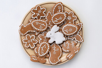 Romantic decorated Easter gingerbread cookies of various shapes on a plate, white background