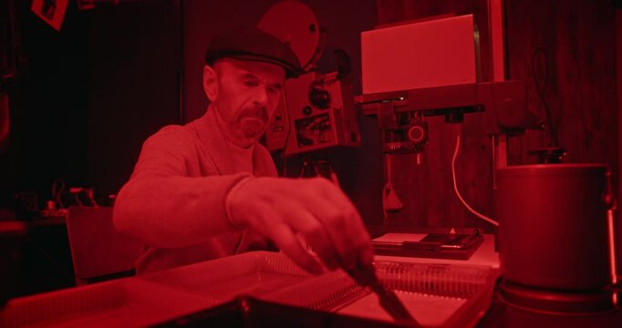 Elderly Man Developing a Black-and-White Photograph in a Vintage Darkroom