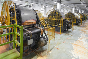 Intricate workings of a vintage carding machine in a textile factory showcasing historical...