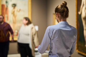Obraz premium visitor in historical museum looking at art object