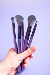 Set of Purple Makeup Brushes on a Light Purple Background
