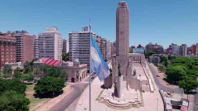 Vista a&eacute;rea de la bandera argentina flameando frente al Monumento Hist&oacute;rico Nacional a la Bandera, Monumento a la Bandera. Rosario, Santa Fe, Argentina. D&iacute;a soleado, Belgrano, turismo, patria