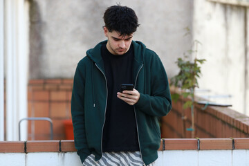 young man or student with mobile phone outdoors